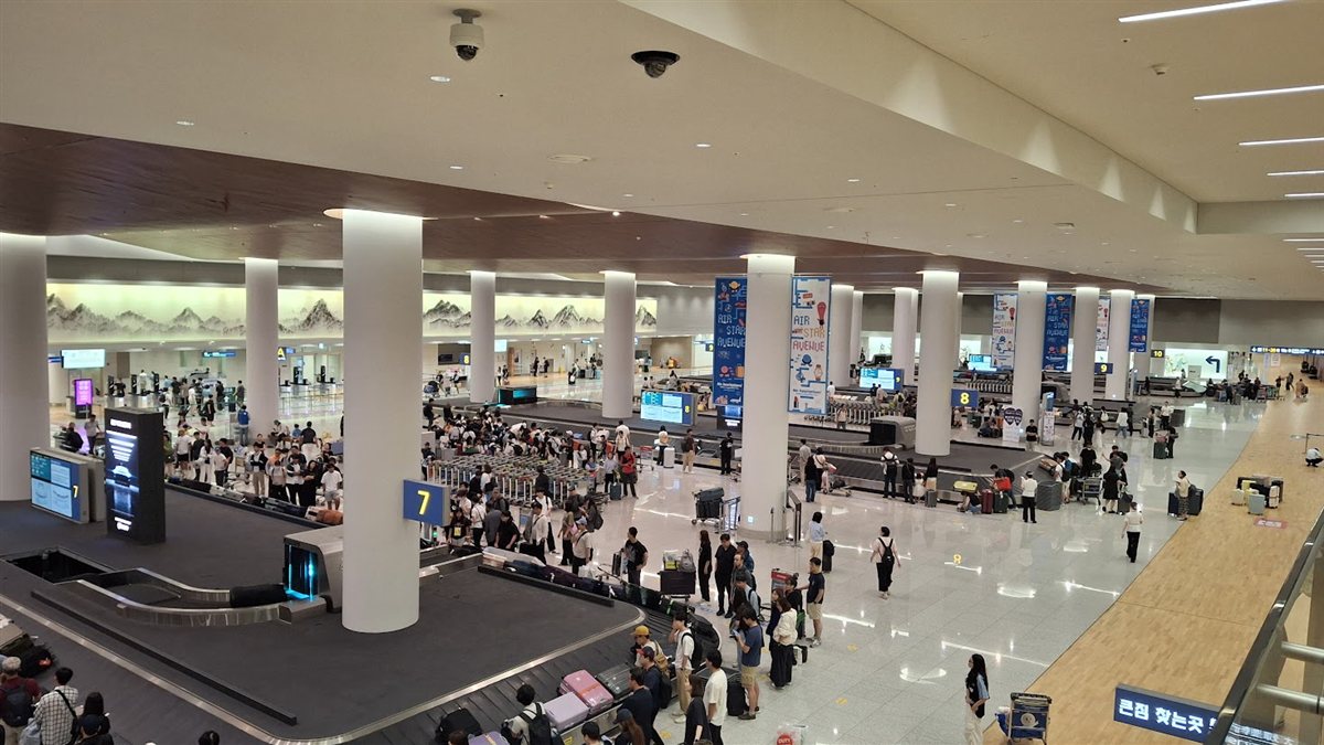 Travelers collecting luggage at the baggage claim in Incheon Airport Terminal 2
