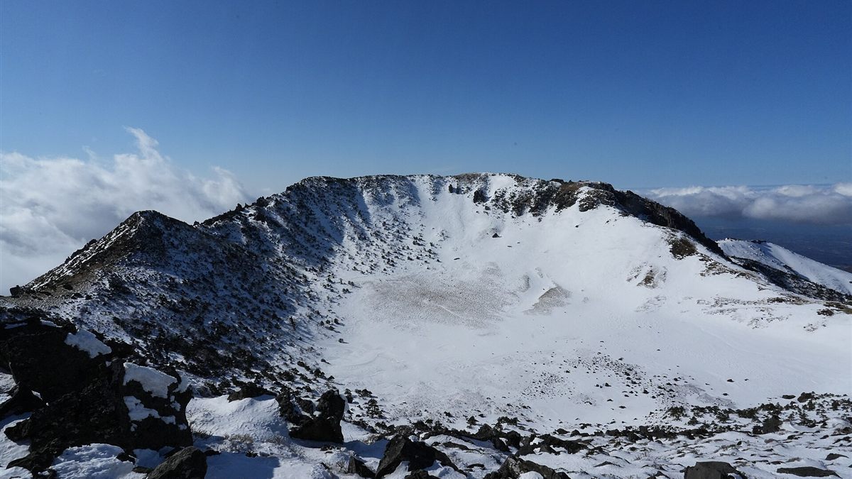 Snow-covered Baengnokdam crater at the summit of Hallasan under a blue sky