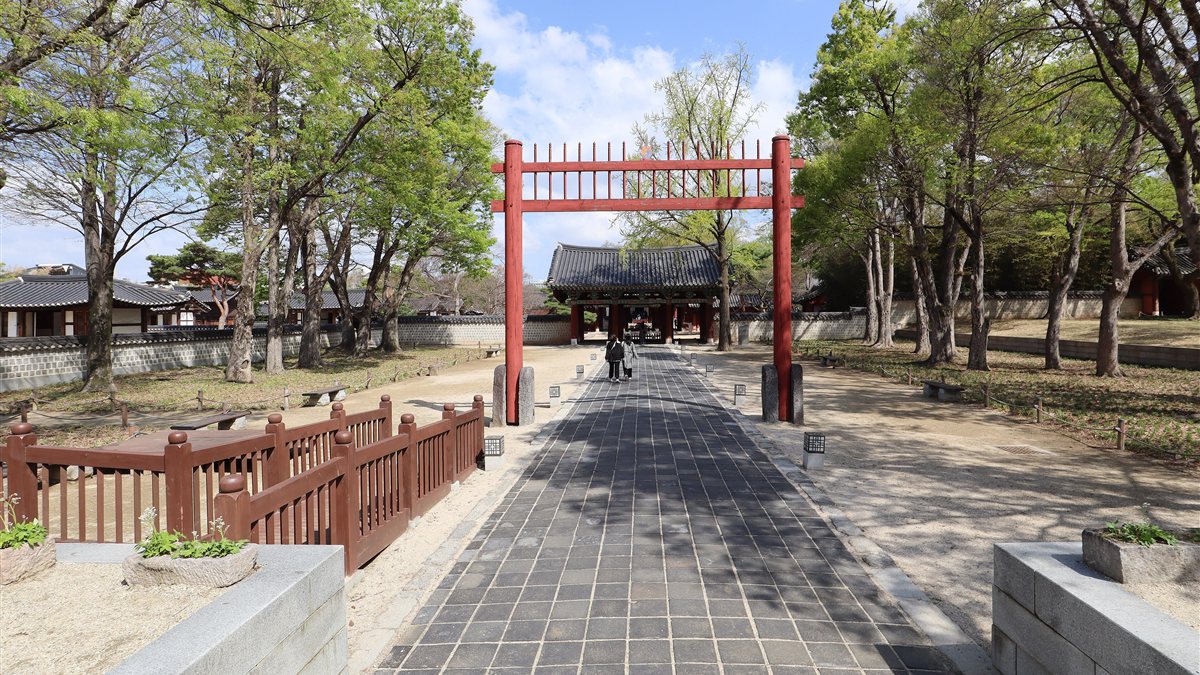 The red gate and stone path leading into Gyeonggijeon Shrine in Jeonju