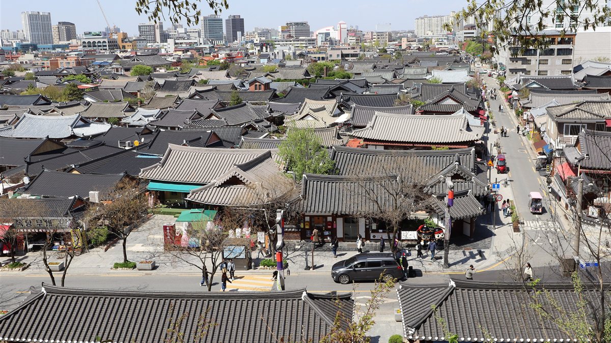 Grey tiled hanok roofs of Jeonju Hanok Village, with the modern city behind