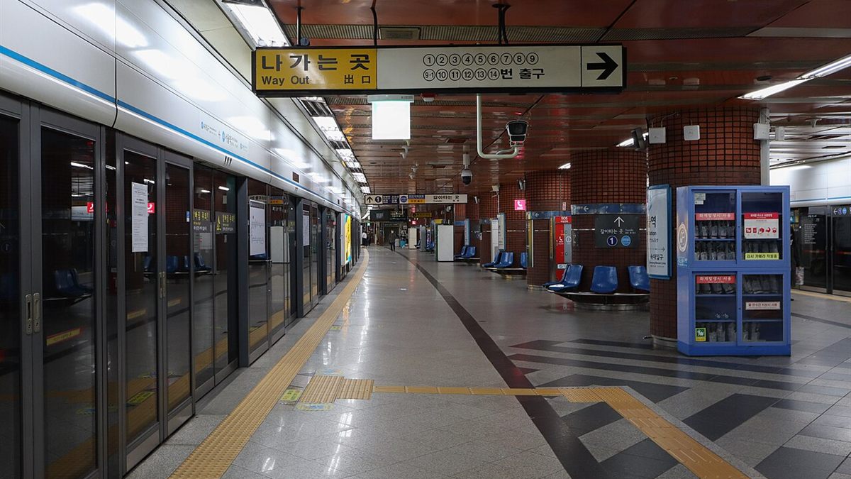Seoul Station platform on Subway Line 4 with a yellow Way Out sign overhead